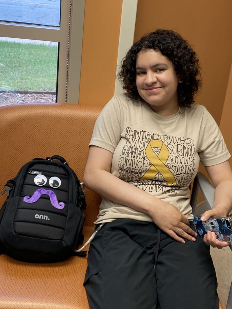 Kenzie poses for a photo with Rhonda, which is what she has named the LVAD's backpack.